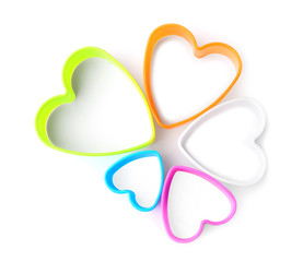 Heart shaped cookie cutters on white background, top view