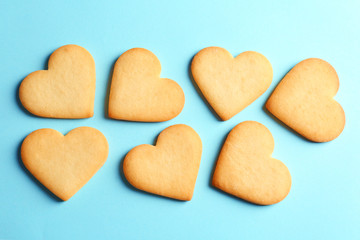 Homemade heart shaped cookies on color background, top view