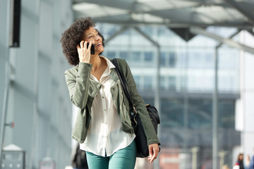 Fototapeta premium smiling african american woman talking with mobile phone