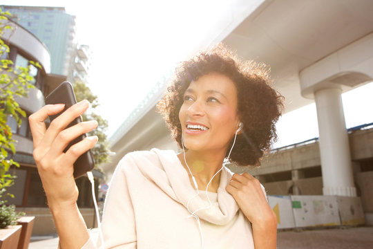 Close Up Smiling Older Woman Listening To Music With Headphones And Smart Phone