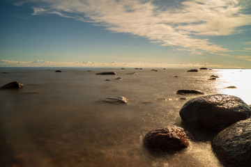 Fototapeta na wymiar rock covered beach in countryside in Latvia, large rocks in water