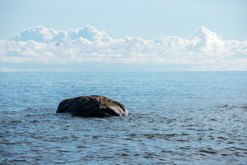 rock covered beach in countryside in Latvia, large rocks in water