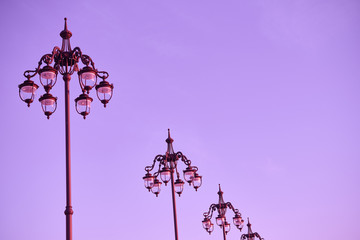 Wrought streetlamps on the background of ultraviolet or magenta sky