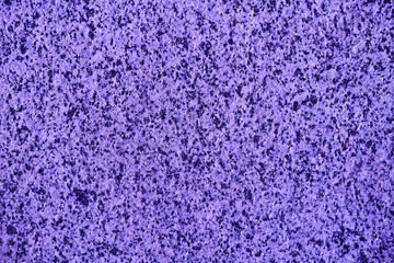The textured ultraviolet or magenta marble chips wall, background