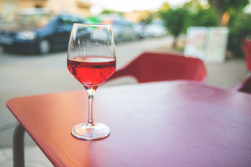 Glass of rose wine on the table in street cafe Vintage toning Selective focus Copy space