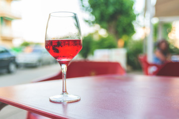 Glass of rose wine on the table in street cafe Vintage toning Selective focus Copy space