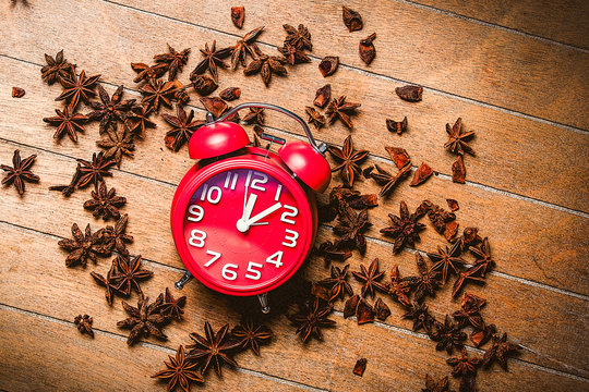 Vintage alarm clock and star anise on wooden background