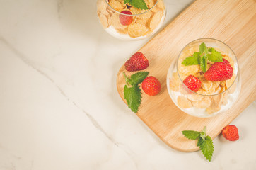 Smoothies with corn flakes decorated mint and strawberry/Smoothies with corn flakes decorated mint and strawberry on wooden tray, top view and copy space