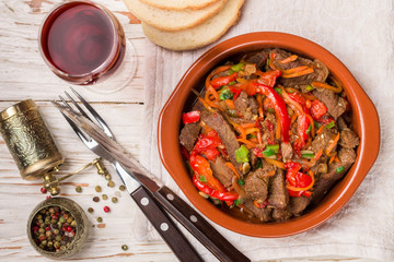 Beef stewed with vegetables-carrots, bell peppers, onions, garlic and spices in ceramic form. A delicious gourmet dinner.  Selective focus