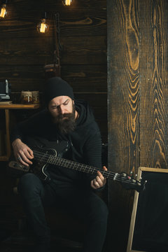 Let the music play. Rock style man. Rock and roll music performer. Electric guitar player. Hipster musician. Bearded man play the guitar. Rock guitarist playing music