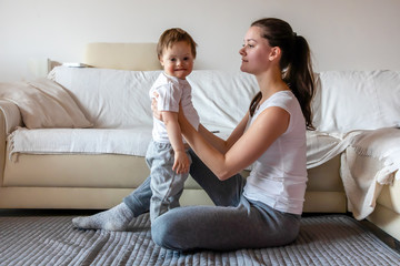 Cute small boy with Down syndrome playing with mother in home