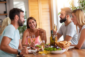 Smiling friends having lunch together at home