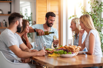 Smiling friends having lunch together at home