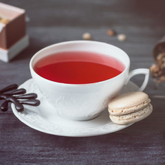 Fruit tea and macaron on a dark wooden background