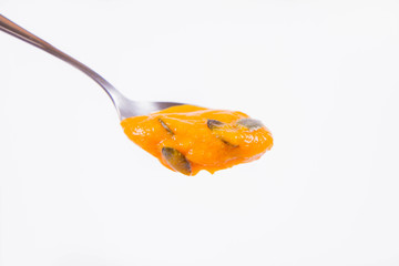 Pumpkin soup  on a spoon on a white background