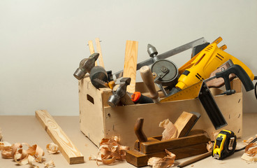 Carpentry concept.Wooden box with many carpentry tools on workplace.