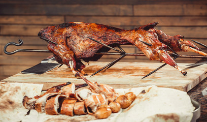 Whole grilled lamb on cutting board. Hot Meat dishes