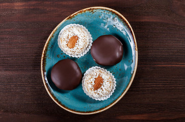 Homemade creamy fudge candies with coconut, raisins, nuts, sesame, peanut, served on the vintage...