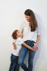Mother and preteen son posing on white background