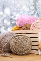 Woolen yarn and fabric on the window sill. Beautiful view outside the window - winter scenery and snow.