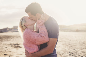 Romantic kiss for young beautiful caucasian couple hugging and loving outdoor with sun backlight - freedom and enjoy life for millennial people - youthful and love concept © simona