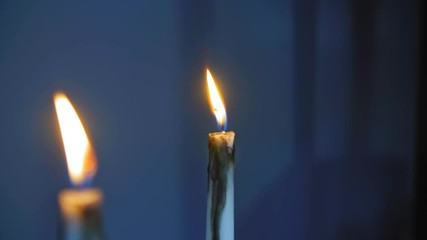 Burning candles over blue background 4K