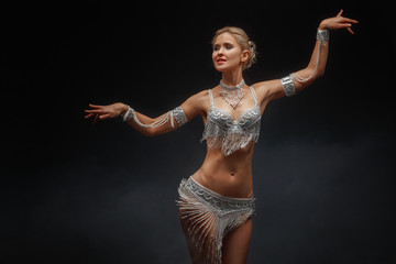 Slender girl blonde in a beautiful costume dancing Oriental dance.