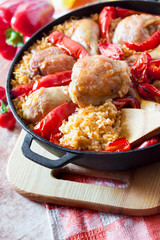 Chicken thighs and legs baked over a bed of rice and red bell pepper