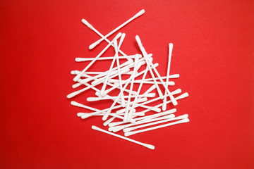 Cotton buds on a red background in the form of an art object for the beauty industry