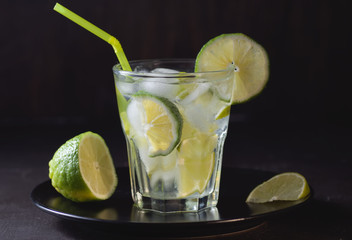 Caipirinha with ice and lime on a wooden table. Summer soft drink.