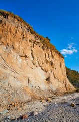 Baltic Sea cliff under clear blue sky.