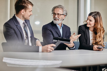 A couple of bussinessmen and bussines woman discussing an important topic