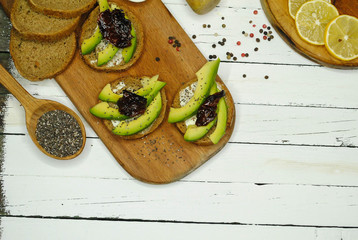Toast with avocado on a wooden plate and white background