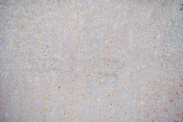 The texture of an old white colored wall with small points of rust, background