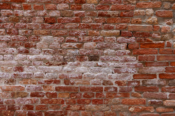 Old damaged red colored brick wall background.
