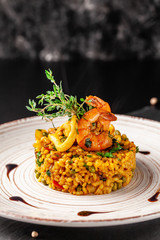 The concept of Spanish cuisine. Paella with seafood, shrimps, squid and greens. Beautiful serving...