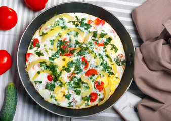 Traditional rustic omelette with bacon, pasta and greens .  Copy space