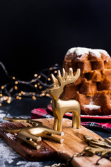 Italian Pandoro Christmas Cake with Lemon Cream. Decor and sweets for Christmas. A bokeh from the garlands and a black background. Winter holiday.