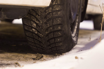 Closeup of car tires in winter on the road covered with snow