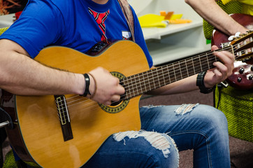 Close Up Of Man Playing Amplified Acoustic Guitar