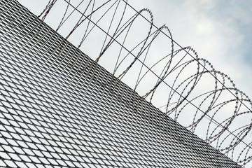Metal fence with barbed wire in the prison.