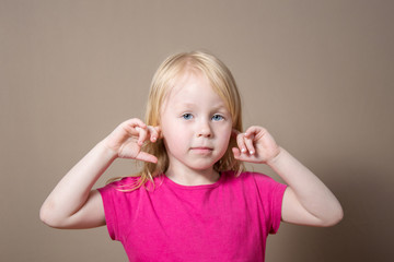 the child does not want to listen, plugs his ears with his fingers. disobedience concept