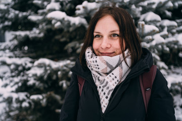 The girl have a rest in the winter woods. Young woman walking through the snow in winter park