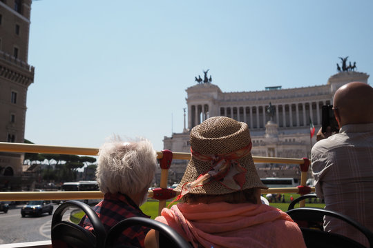 Open top bus tour, tourists taking pictures of the Altare della Patria, Rome, Italy