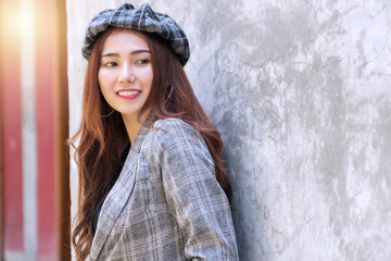 Traveler smiling young woman sitting on sidewalk in city looking at something with feeling relaxed and happy in tourist. Lifestyle travel concept.