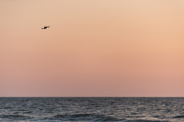 Naples, Florida red and orange sunset, one drone flying, in gulf of Mexico with nobody landscape, horizon, silhouette
