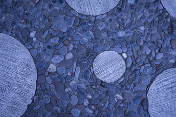 pared de piedras y circulo de concreto negras azules y grises
