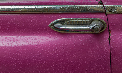 Purple classic car door in rain in Havana Cuba
