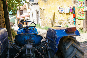 Fototapeta na wymiar Blue tractor on a narrow streen in Cumalikizik, Bursa, Turkey