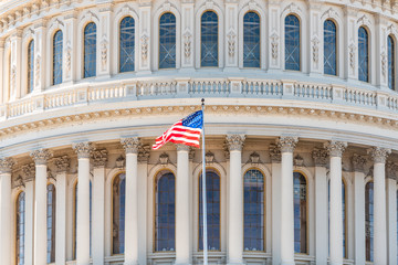 US Congress dome closeup with American flag waving in Washington DC, USA on Capital capitol hill,...